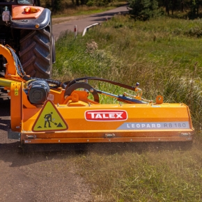 Pomarańczowa kosiarka bijakowa firmy TALEX model RB 180 podczas koszenia pobocza drogi