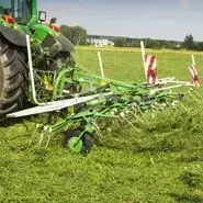 Przetrząsacz zawieszany Samasz model P4 podczas pracy na łące