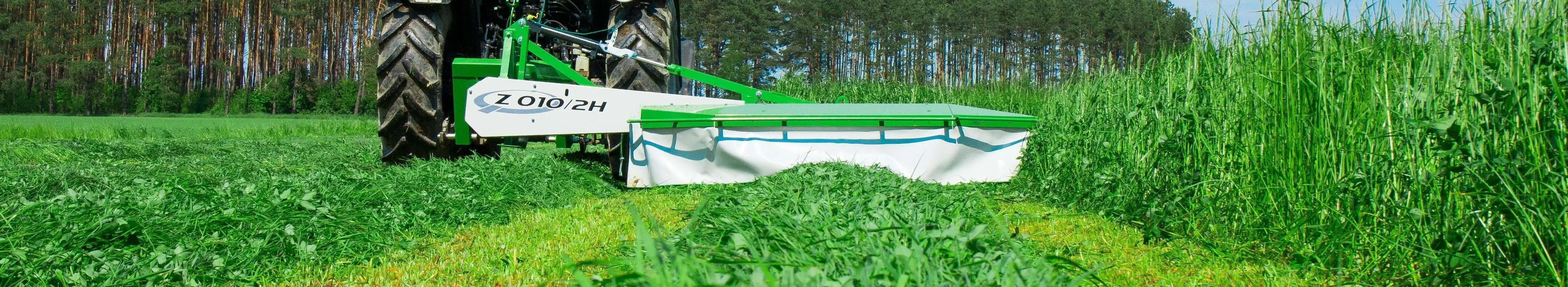 Zielona kosiarka bębnowa zawieszana tylna Z010/2H produkowana przez Samasz kosi trawę na łące. korbanek.pl