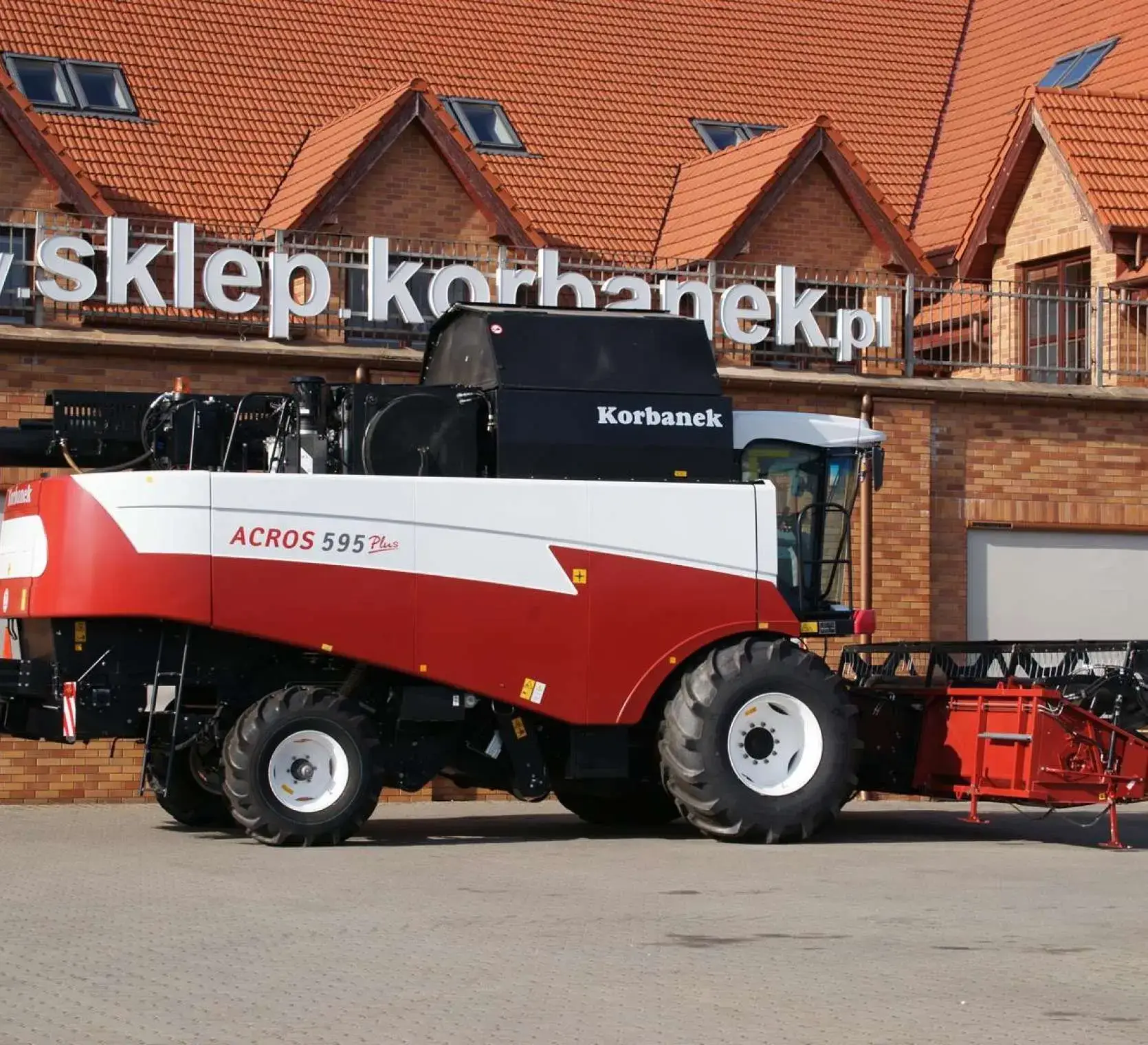 Widok z boku Rostselmasha Acros 595 + na tel sklepu Korbanek. Zdjęcie przedstawiające kombajn zbożowy Acros 595 +.