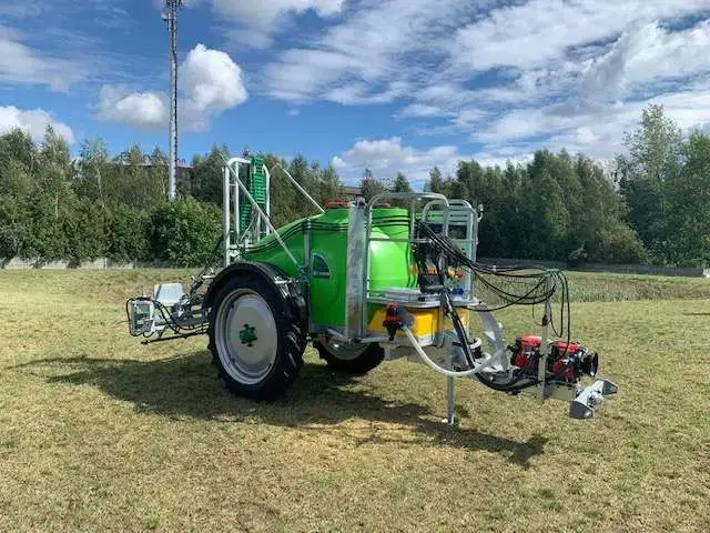 Maszyna jest widoczna częściowo z boku i z przodu widok na pompę dyszel zbiornik zielony elementy ocynkowane Opryskiwacz zaczepiany Tolmet Bruno Borys Klara