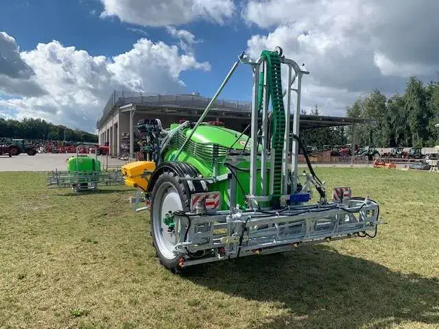 Opryskiwacz widoczny na tle serwisu Korbanek widok na złożona belke polową Opryskiwacz zaczepiany Tolmet Bruno stosowany do ochrony roślin zaczepiany polowy belka 15 metrów