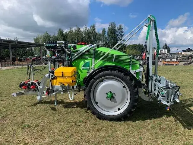 Opryskiwacz zaczepiany o pojemności 1500 litrów i o belce polowej 15 metrów na zdjęciu jest widoczny z boku lewa strona widok na koło i dyszel zaczepowy Opryskiwacz zaczepiany Tolmet Bruno Borys Klara