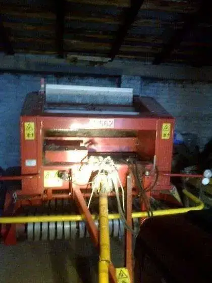 sprzedam używana prasa zwijająca Metal-Fach Sokółka 2003 zdjęcie od przodu maszyny robione po zmroku