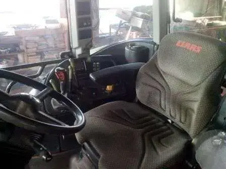 Ciągnik rolniczy CLAAS Ares 657 zdjęcie wnętrza kabiny Regulowana kolumna kierownicy, pneumatyczny fotel operatora w klimatyzowanej i ogrzewanej kabinie w traktorze CLAAS Ares 657