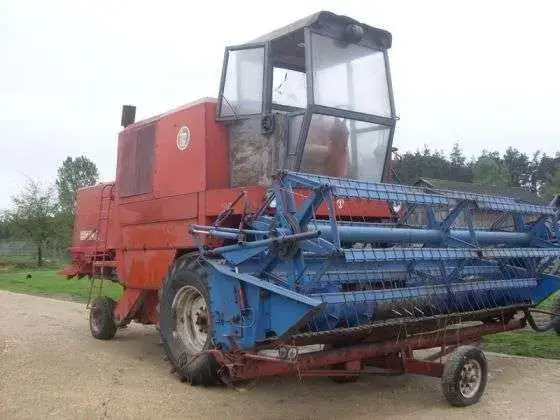 kombajn zbożowy BIZON Z 056 1978 r używanyz wózkiem transportowym używany kombajn zbożowy BIZON Z 056 1978 r czerwony z niebieskim hederem