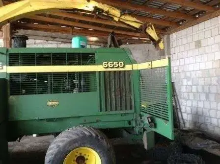 Fotografia boku i otwartej komory z tyłu sieczkarni John Deere 5650.