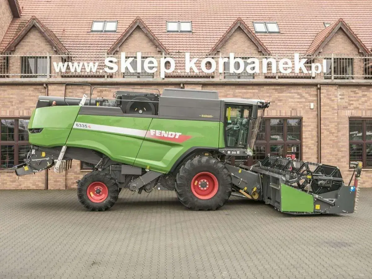 Używany kombajn zbożowy Fentd 6335 z 9000 l. zbiornikiem na ziarno Prawy bok używanego kombajnu Fendt 6335 na tle spółki Korbanek