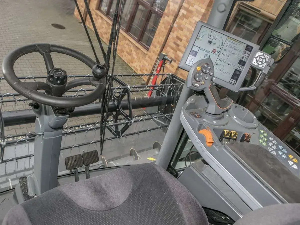Wnętrze kabiny z kierownicą i panelem sterującym w kombajnie Fendt 6335 Kierownica i panel strowania w kabinie uzywanego kombajnu Fendt 6335 od www.korbanek.pl