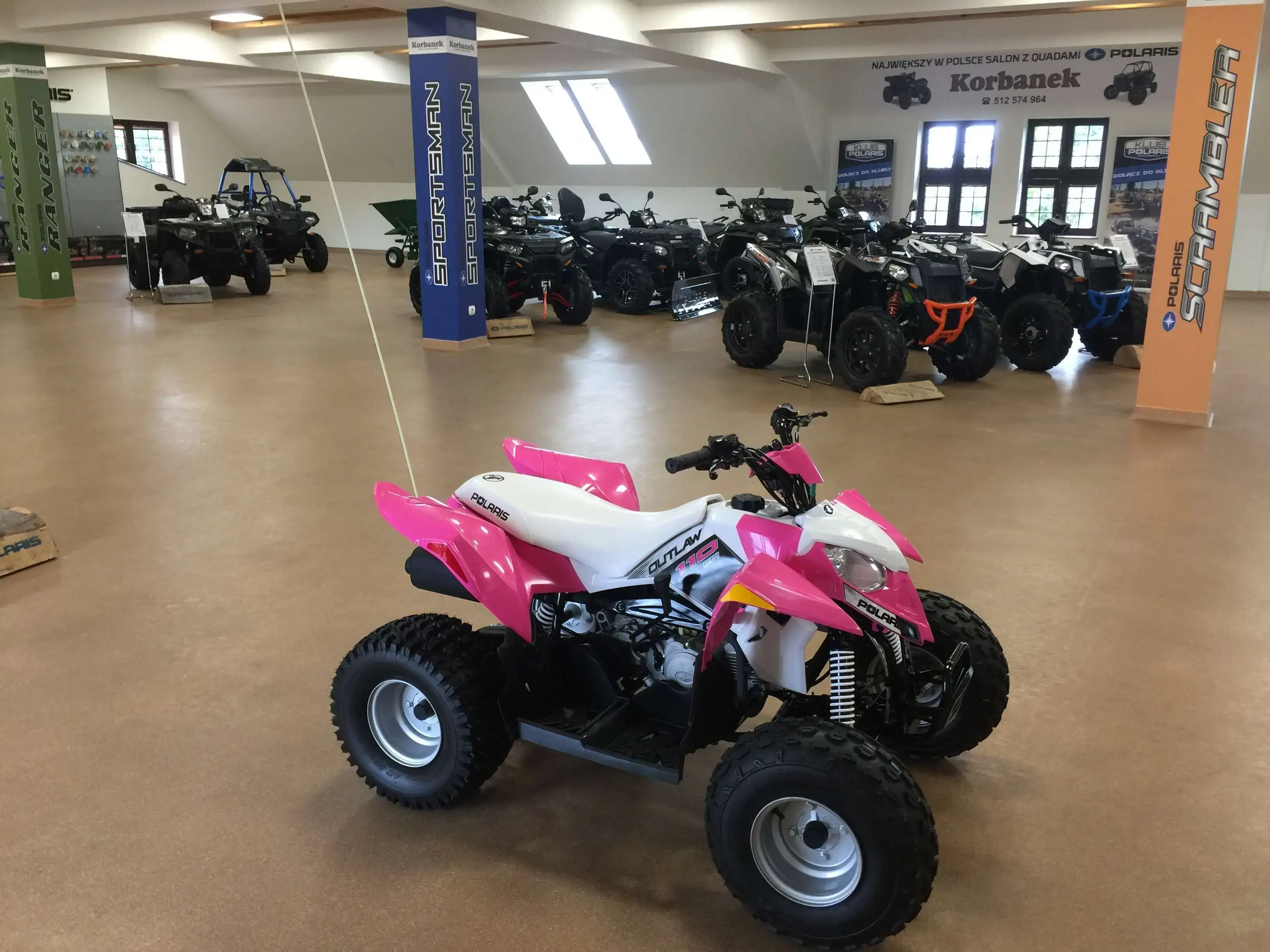 Różowy POLARIS OUTLAW 110 Rózowy Outlaw 110 na tle wielu madeli qudów Polariz z salonu spółki Korbanek