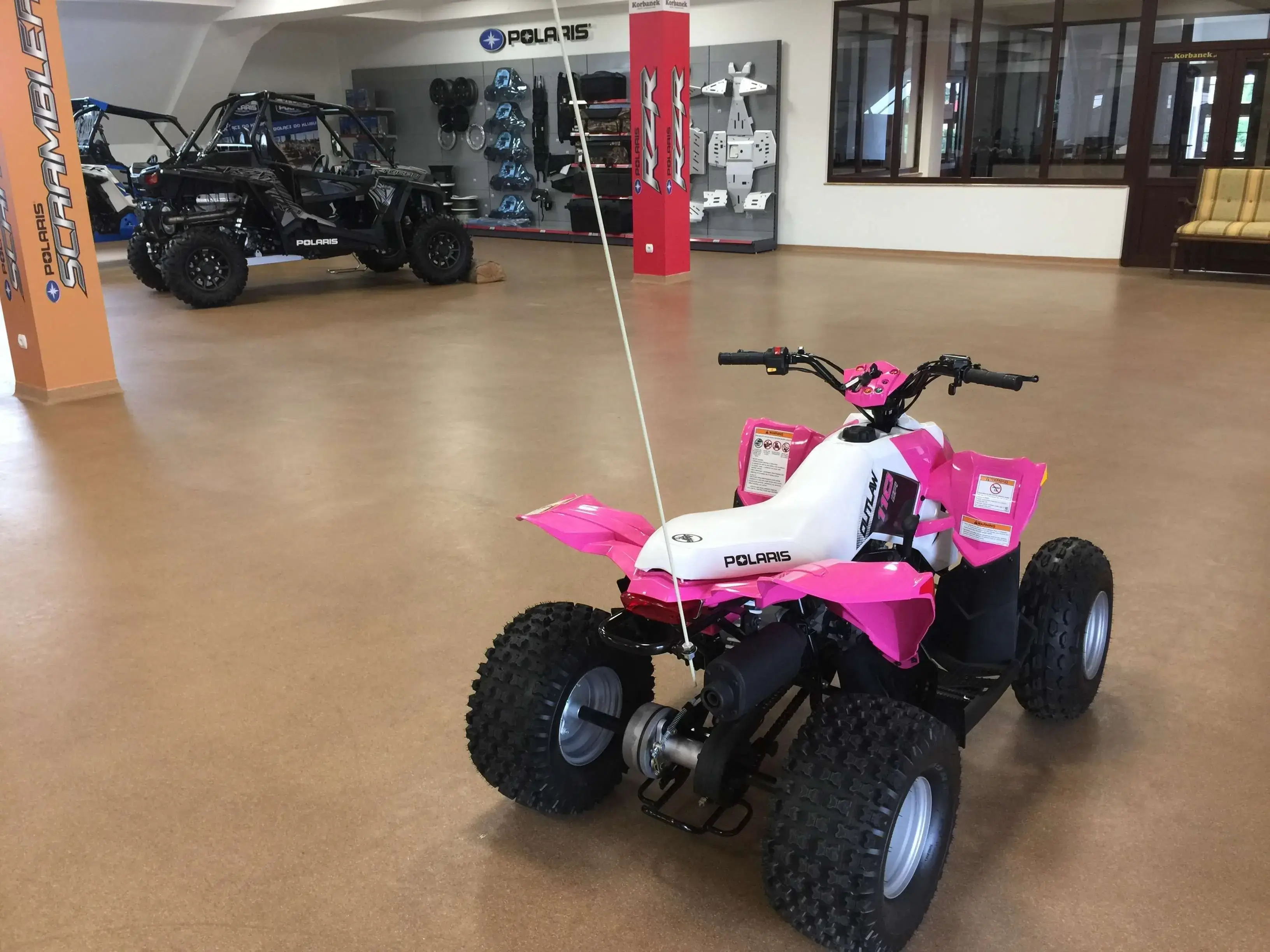 Różowy mały Quad Outlaw 110 na salonie quadów spółki Korbanek Tył różowego pojazdu typu quad marki Polaris seria Outlaw 110