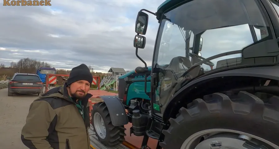 Nowy nabytek Klienta - ciagnik Aupax 3075 podczas rozładunku w jego gospodarstwie Klient firmy Korbanek przy swoim nowym nabytku ciagniku Aupax 3075