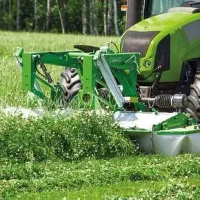 Zielona kosiarka czołowa dyskowa KDF 300 firmy Samasz zawieszona na zielonym ciągniku firmy CLAAS kosi trawę. 