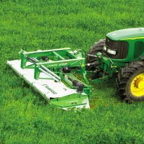 Zielony ciągnik John Deere wraz z zieloną czołową kosiarką dyskową firmy SaMASZ typ KDF 300 kosi pastwisko.