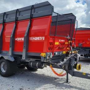 Czerwony rozrzutnik obornika 10-tonowy firmy Metal-fach model N267/2 na zwieszeniu Tandem