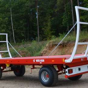 Czerwona przyczepa do wożenia bel 9-tonowa firmy Metalfach model T014/2 z wysuwaną podłogą