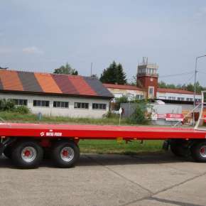 Czerwona przyczepa do wożenia bel 11,4t firmy Metalfach model T009/1 z wysuwaną podłogą