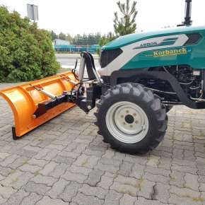 Widok z boku pomarańczowy pług do śniegu T-218/2 zamontowany na ciągniku ARBOS www.korbanek.pl
