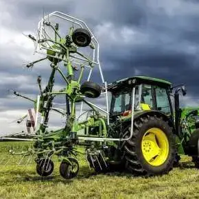 Zielony ciągnik rolniczy John Deere z ładowaczem z zawieszony przetrząsaczem P6-771 do trawy firmy samasz www.korbanek.pl