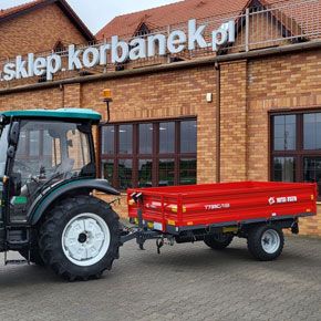 Czerwona przyczepa wywrotka T735C/1 o ładowności 3200 kg firmy Metal-Fach podczepiona do ciągnika ARBOS 3055