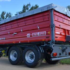 Czerwona przyczepa rolnicza tandemowa T730/3 firmy Metal-Fach. Wyposażona w nadstawki i plandekę.