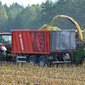 Czerwona rolnicza przyczepa uniwersalna firmy Metalfach model T935/6 LionPOWER z wypychaną ścianą 