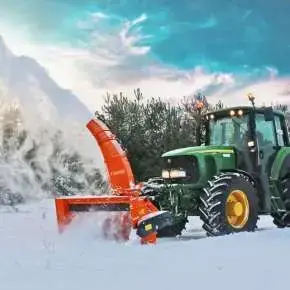 Zielony ciągnik rolniczy John Deere z podczepionym pługiem wirnikowym TORNADO 252 odśnieża drogę www.korbanek.pl