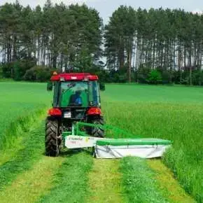 Kosiarka bębnowa rotacyjna typ Z010H firmy Samasz zawieszona na czerwonym ciągniku podczas koszenia łąki www.korbanek.pl