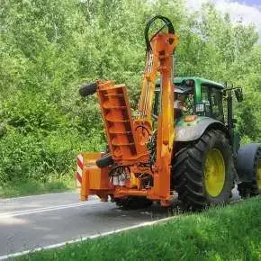 Widok z tyłu ciągnika rolniczego z zamontowaną przystawką do frezowania poboczy na ramieniu KWT www.korbanek.pl