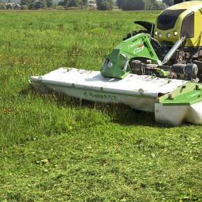Widok od przodu traktora rolniczego Claas z zawieszoną kosiarką przednią dyskową XT-F  firmy SaMASZ