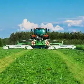 Widok od tyłu czerwonego traktora rolniczego koszącego trawę kosiarkami dyskowymi MegaCUT KDD 941 firmy Samasz  www.korbanek.pl