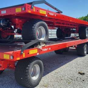 Czerwona przyczepa do transportu bel model T009/1 firmy Metal-Fach o ładowności 11400 kg