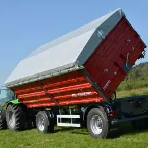 Czerwona przyczepa rolnicza wywrotka model T739 firmy Metal-Fach wyposażona w plandekę i dodatkowe burty