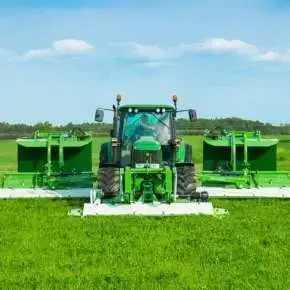 Ciągnik rolniczy John Deere w kolorze zielonym z zestawem kosiarek dyskowych GigaCUT ze złożonymi transporterami www.korbanek.pl