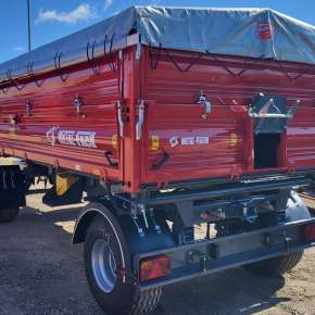 Czerwona przyczepa rolnicza z nadstawkami T940/2 firmy Metal-Fach. Wysyp tylny ułatwia sterowaniem wysypem ziarna.