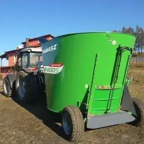 Widok z tyłu zielonego wozu paszowego jednoślimakowego samasz OptiFEED UNO i jego tylnego, centralnego otworu wysypowego www.korbanek.p