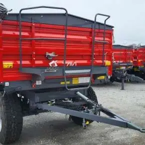 Czerwona przyczepa rolnicza wywrotka model T711/1 firmy Metal-Fach wyposażona w plandekę i dodatkowe burty