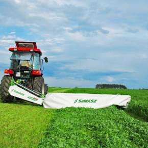 Traktor w kolorze czerwonym z kosiarką dyskową SAMBA 280 firmy Samasz kosi łąkę www.korbanek.pl