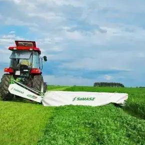 Traktor w kolorze czerwonym z kosiarką dyskową SAMBA 280 firmy Samasz kosi łąkę www.korbanek.pl