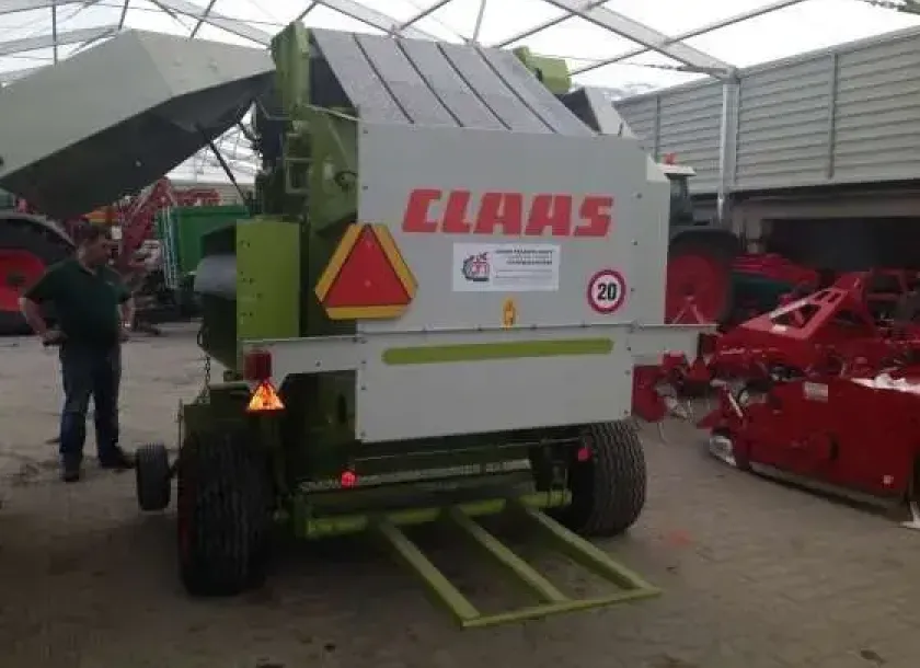 używany Prasa Claas Variant 260 w hali na tle maszyn