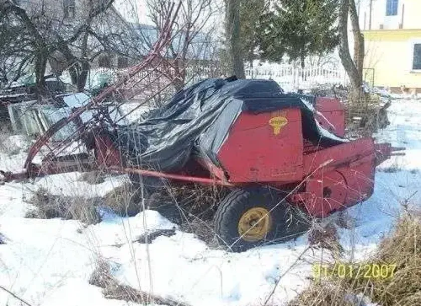 prasa kostkująca Welger AP 45 1980 r przykryta plandeką i okryta śniegiem