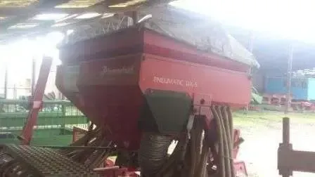 Pod wiatą stoi używany siewnik pneumatyczny Marki ACORD PNEUMATIC DA-S 4,5 metra szerokości roboczej