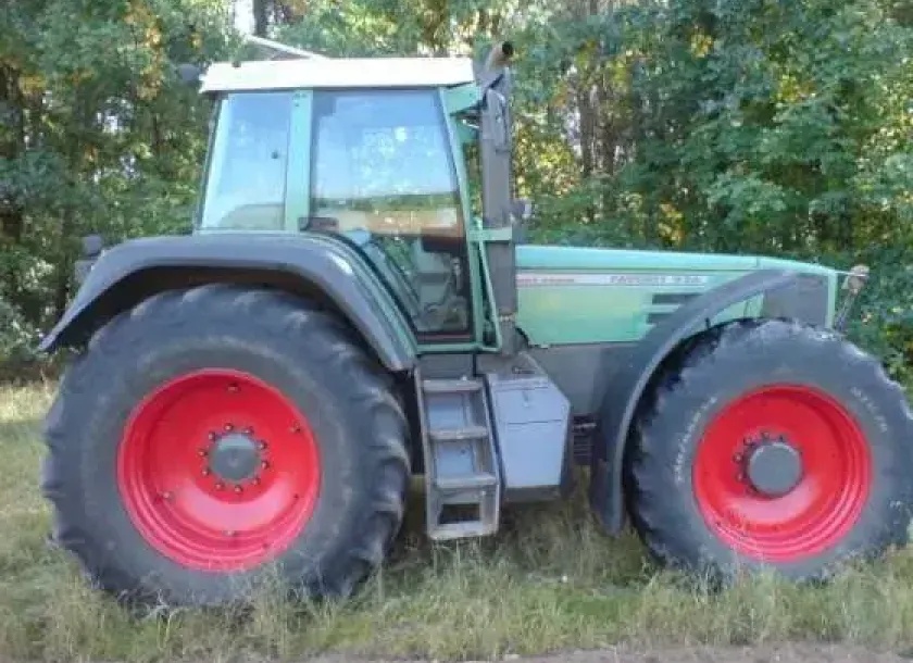 Używany ciągnik rolniczy Fendt 926 Vario widok na prawy bok na tle zarośli 