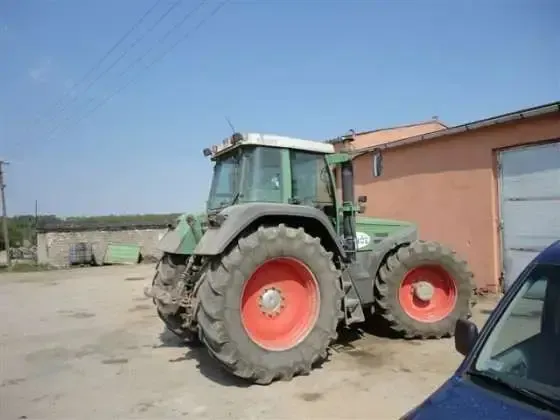 Praawy bok używanego ciągnika Fendt Favorit 824 na tle zabudowań gospodarczych 