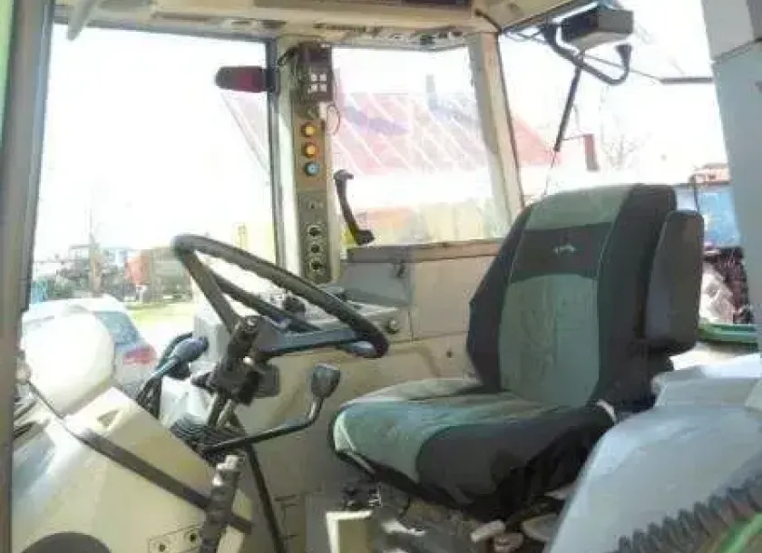 Wnętrze zadabnego używanego ciągnika rolniczy marki Fendt 515 C widok na siedzenie operatora i kierownicę 