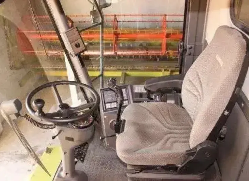 Claas Medion 310 używany - wnętrze kabiny widok na fotel operatora