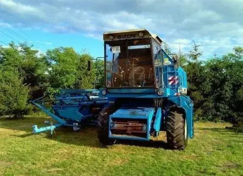 używany kombajn zbożowy Bizon Rekord Z 058 1997 r zdjęcie na tle zieleni od przodu maszyny