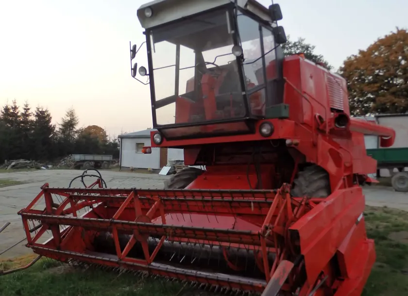 prawy bok używany kombajn zbożowy Bizon Z056 kolor czerwony z sieczkarnią do słomy