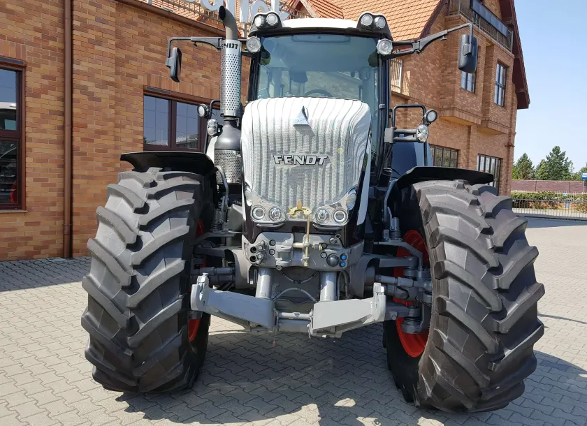Używany czarny ciagnik Fendt 936 widok z przodu na tle klinkierowego budynku