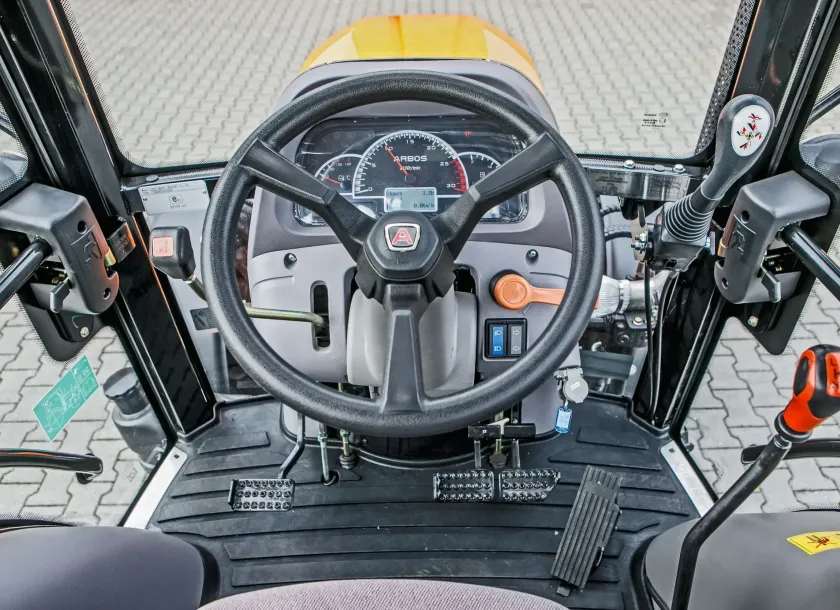 Wnętrze ciągnika Arbos 3055 z deską rozdzielczą i joystickiem do sterowania przednim TUZ